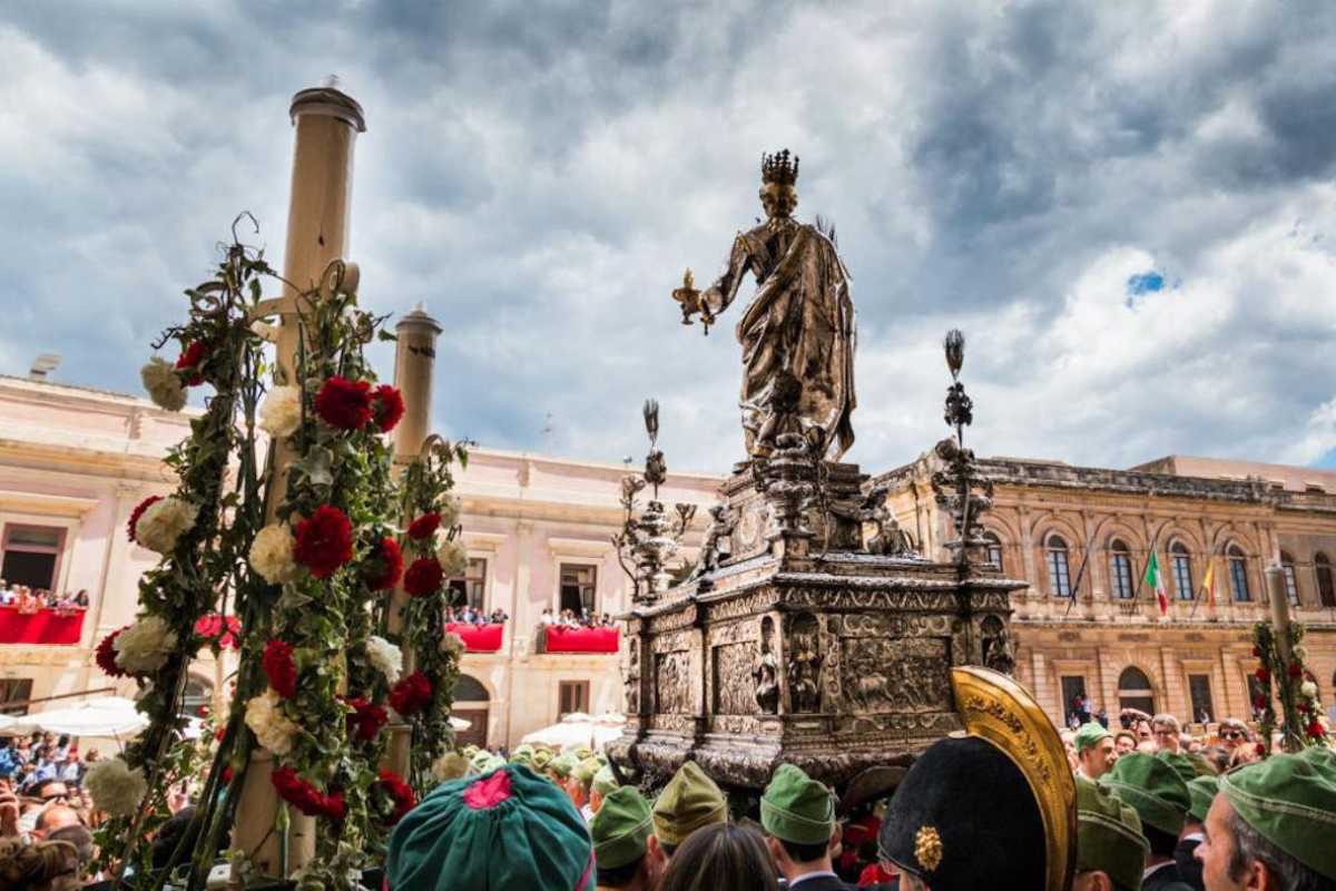 Scorcio panoramico del Teatro Antico di Taormina durante un evento serale, pubblico in festa e le luci della città sullo sfondo