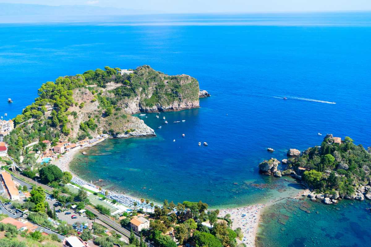 Vista panoramica aerea su Isola Bella e le sue spiagge, mare cristallino, vegetazione mediterranea, Taormina sullo sfondo.